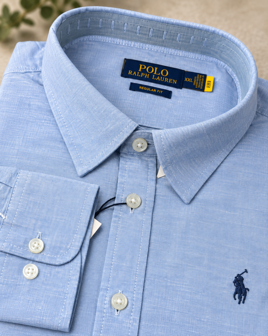 Stitching and construction detail on the baby blue shirt